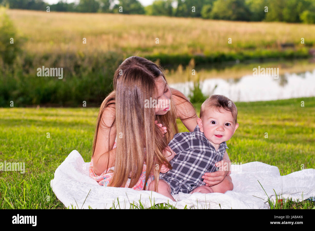Mädchen halten Baby auf Decke Natur Landschaft Stockfoto
