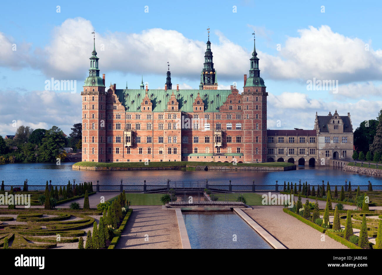 Schloss Frederiksborg im niederländischen Renaissance-Stil und der Garten des Barock. Hillerød, Nordsealand. Morgensonne, Wolken, die mystisches Licht und Schatten werfen Stockfoto