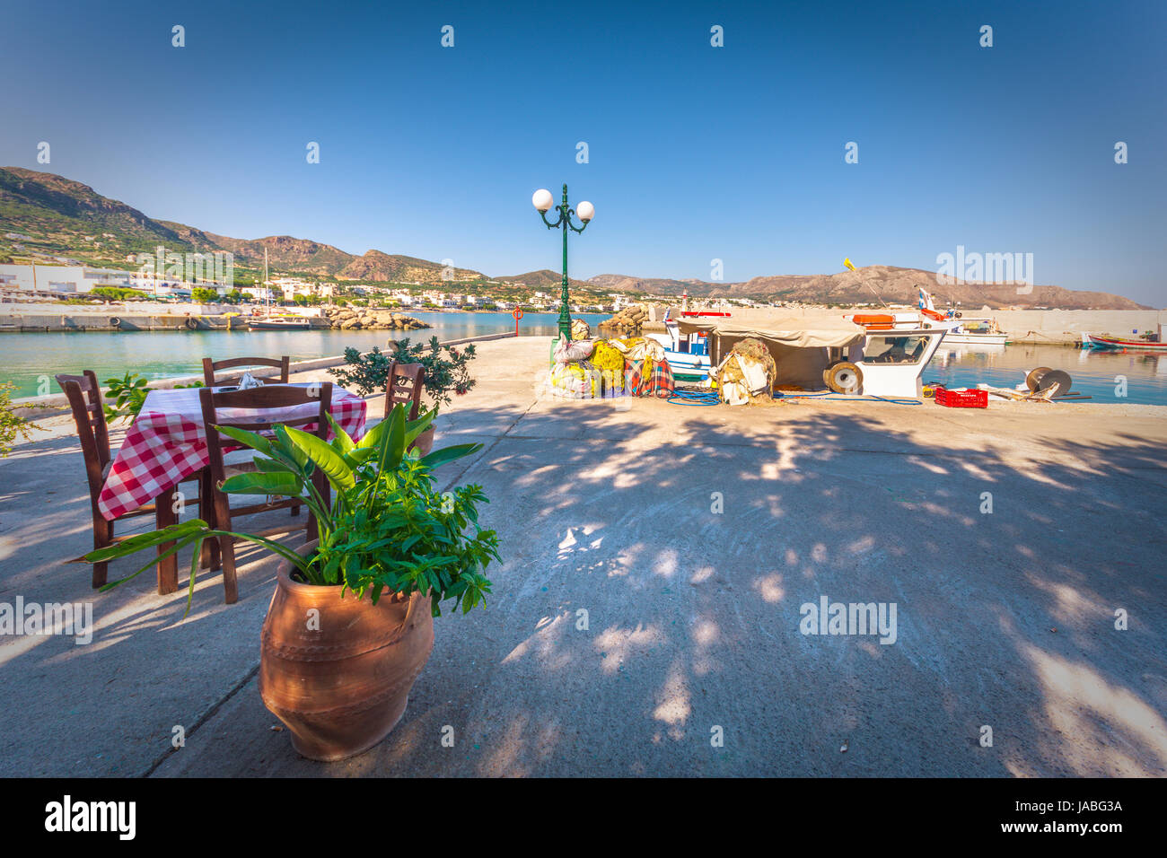 Stühle mit Tischen im typisch griechischen Taverne am Hafen von Makri Gialos, Kreta, Griechenland. Stockfoto