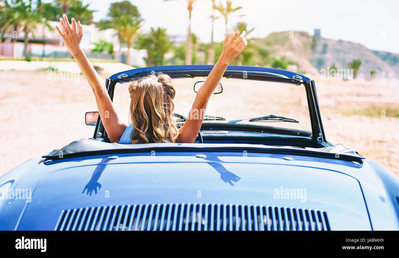 Frau mit einem Handzeichen in Retro-Cabrio Auto sitzen. Ansicht von hinten Stockfoto