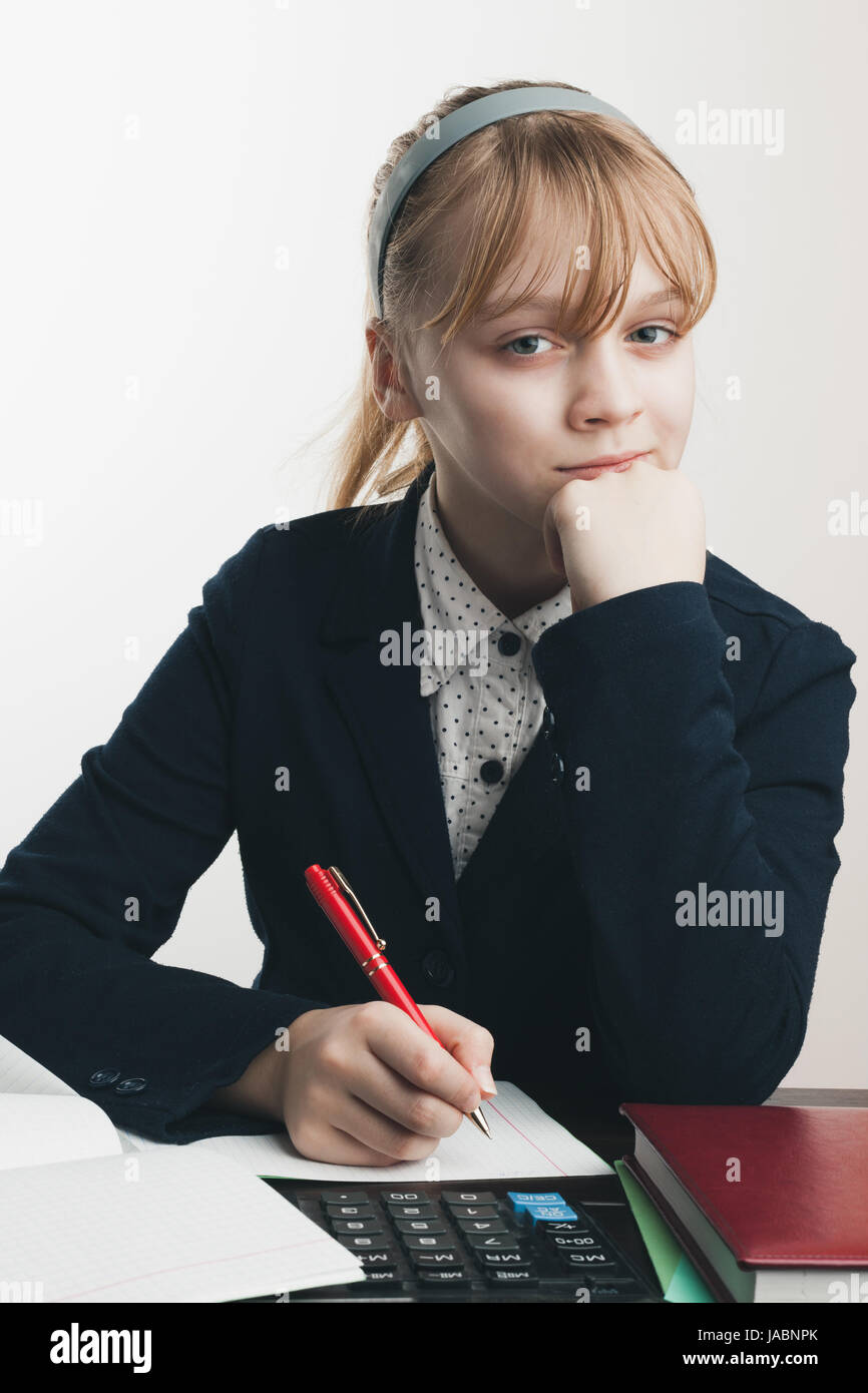 Sitzen Schulmädchen, Closeup Portrait über weiße Wand Hintergrund Stockfoto