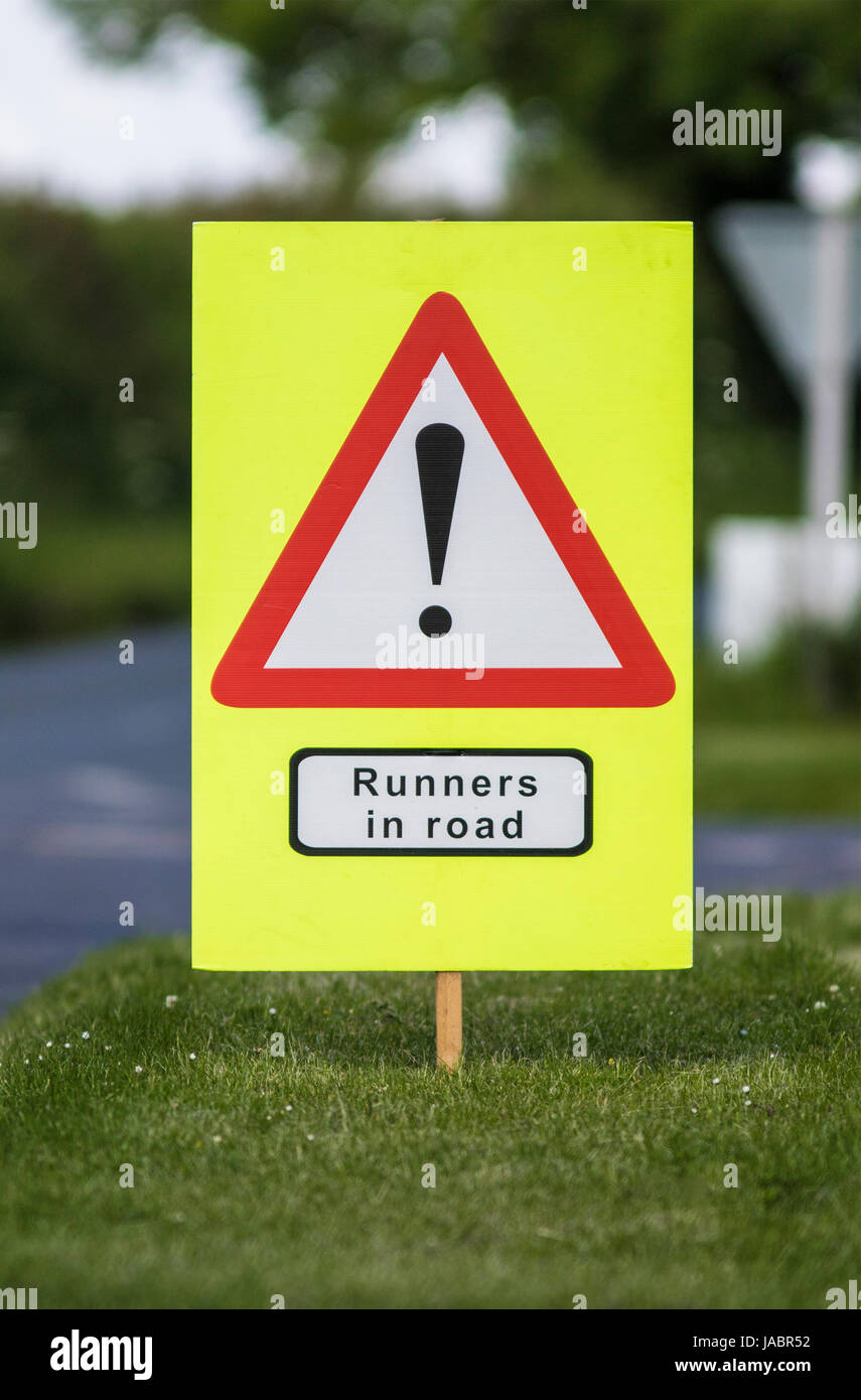 Quenington, UK - 4. Juni 2017: Warnschild, laufen Läufer in der Straße im Dorf Quenington, Gloucestershire in Fairford 10 K Stockfoto