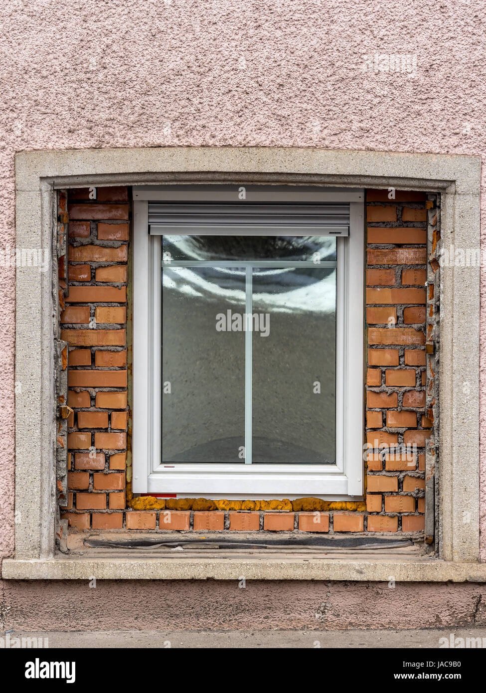 In einem alten Wohnhaus wurde ein großes Fenster mit einer neuen ersetzt. Symbol für alte Haus Renovierung und Verbesserung der Wohnfläche, Einem alten Wohnhau Stockfoto