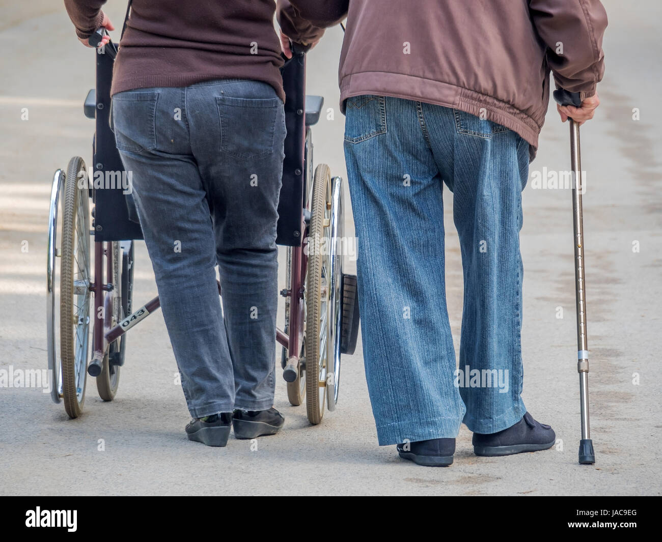 Mann und Frau gehen für einen Spaziergang mit Rollstufl und walking Stock, Mann Und Frau Gehen Mit Rollstufl Und Gehstock spazieren Stockfoto