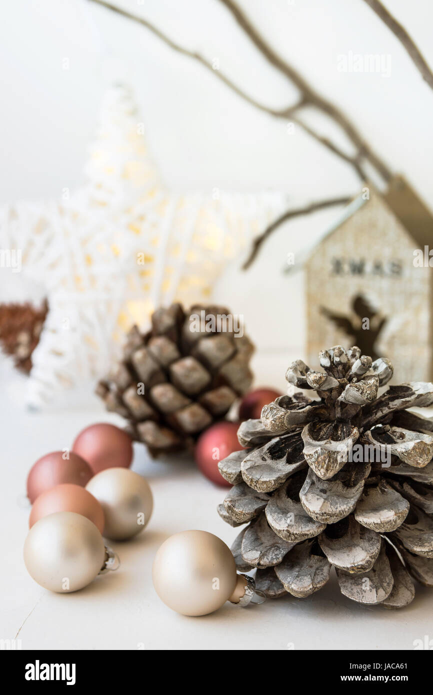 White Christmas-Dekoration-Zusammensetzung, großer Tannenzapfen, verstreuten Kugeln, glänzenden Stern, hölzerne Kerzenständer, trockene Äste im Hintergrund, skandina Stockfoto