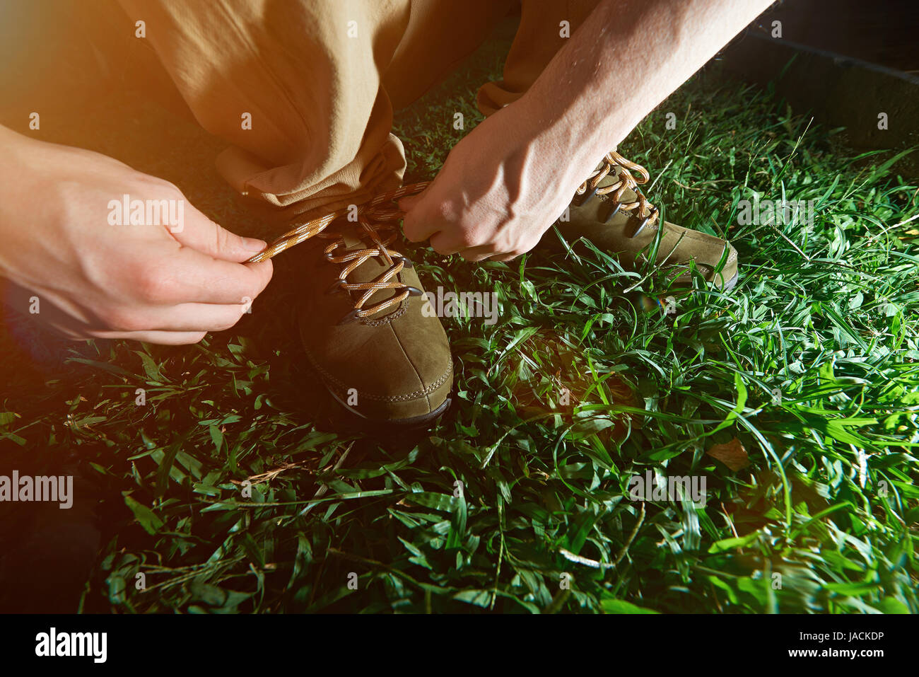 Mann, die Schnürsenkel zu binden, auf seine aktiven Schuhe Closeup grün Hintergrund Stockfoto