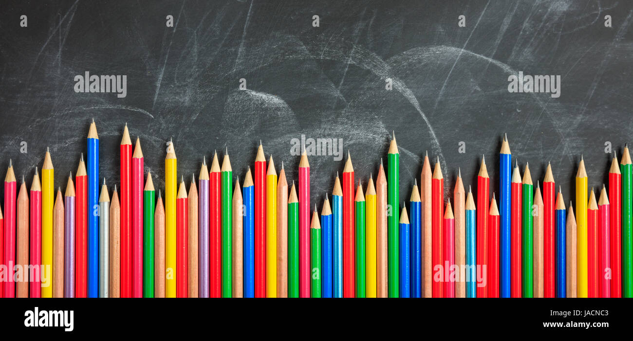 Farbige Bleistifte aus Holz auf einer schwarzen Tafel Stockfoto