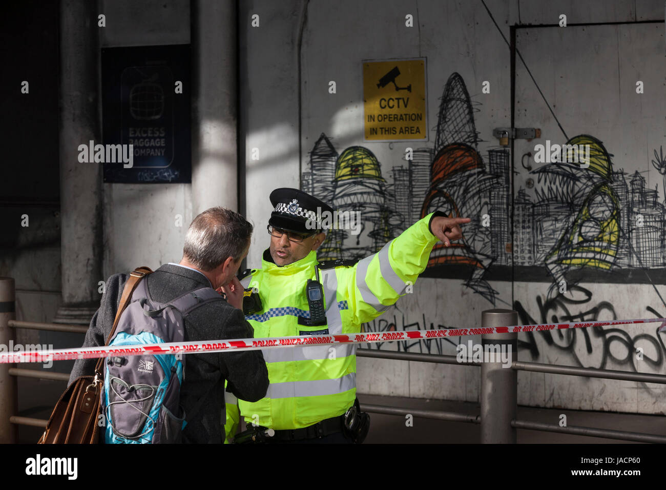 36 Stunden nach der London Bridge und Borough Market Terroranschlag, die Hauptstadt zurück zur Normalität und Londoner zurück zu ihrem ersten Tag zu arbeiten, damit Polizisten mit Wegbeschreibungen helfen, da Straßen für den Verkehr und Fußgänger verwenden, auf Montag, 5. Juni 2017, im Stadtteil South London Southwark, England noch geschlossen sind. Sieben Menschen wurden getötet und viele andere Links mit lebensverändernden Verletzungen- aber der britischen Geist des Trotzes und weiterhin mit täglichen Lebens erträgt. Stockfoto