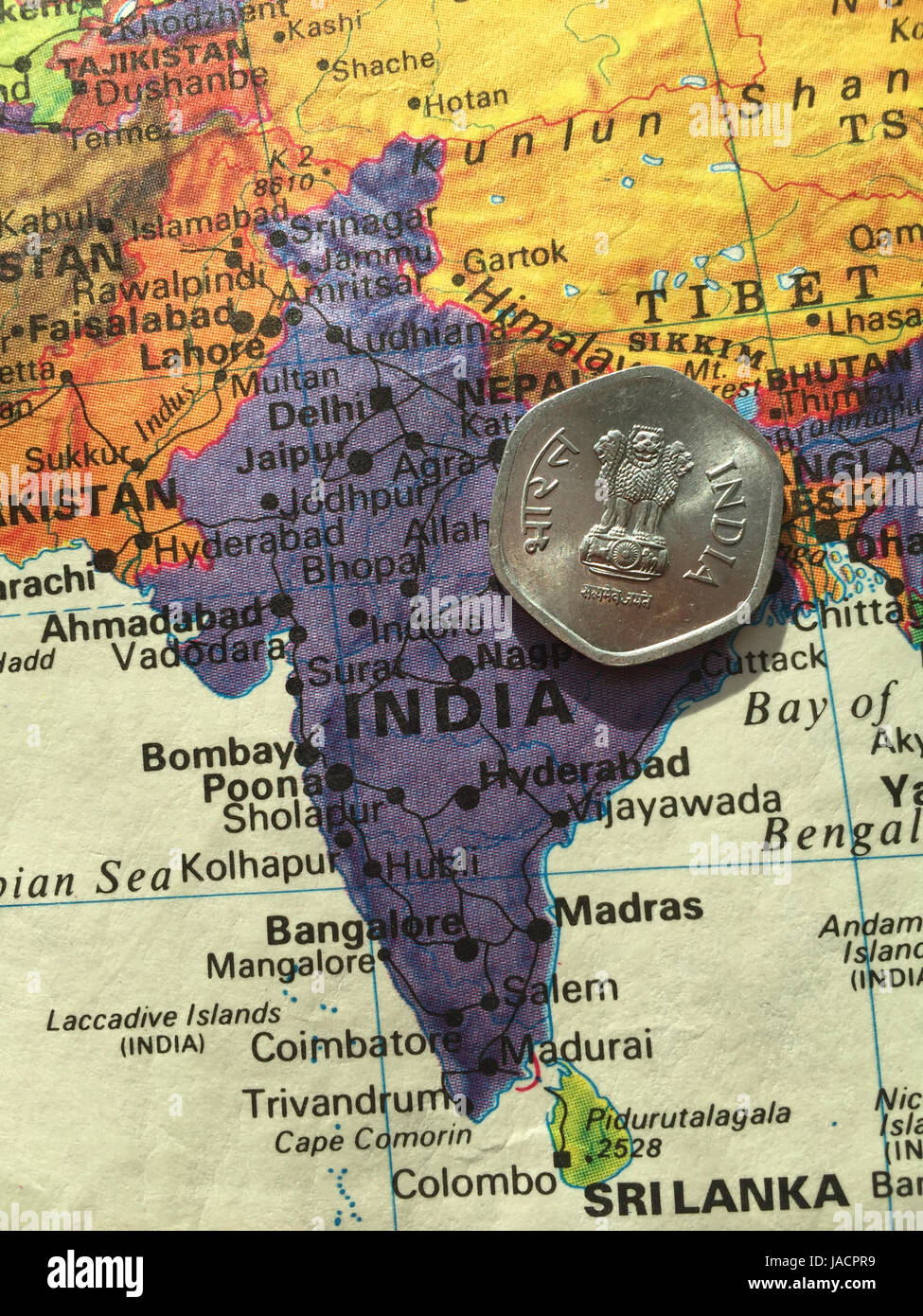 Indische Rupie-Münze auf Weltkarte Stockfoto
