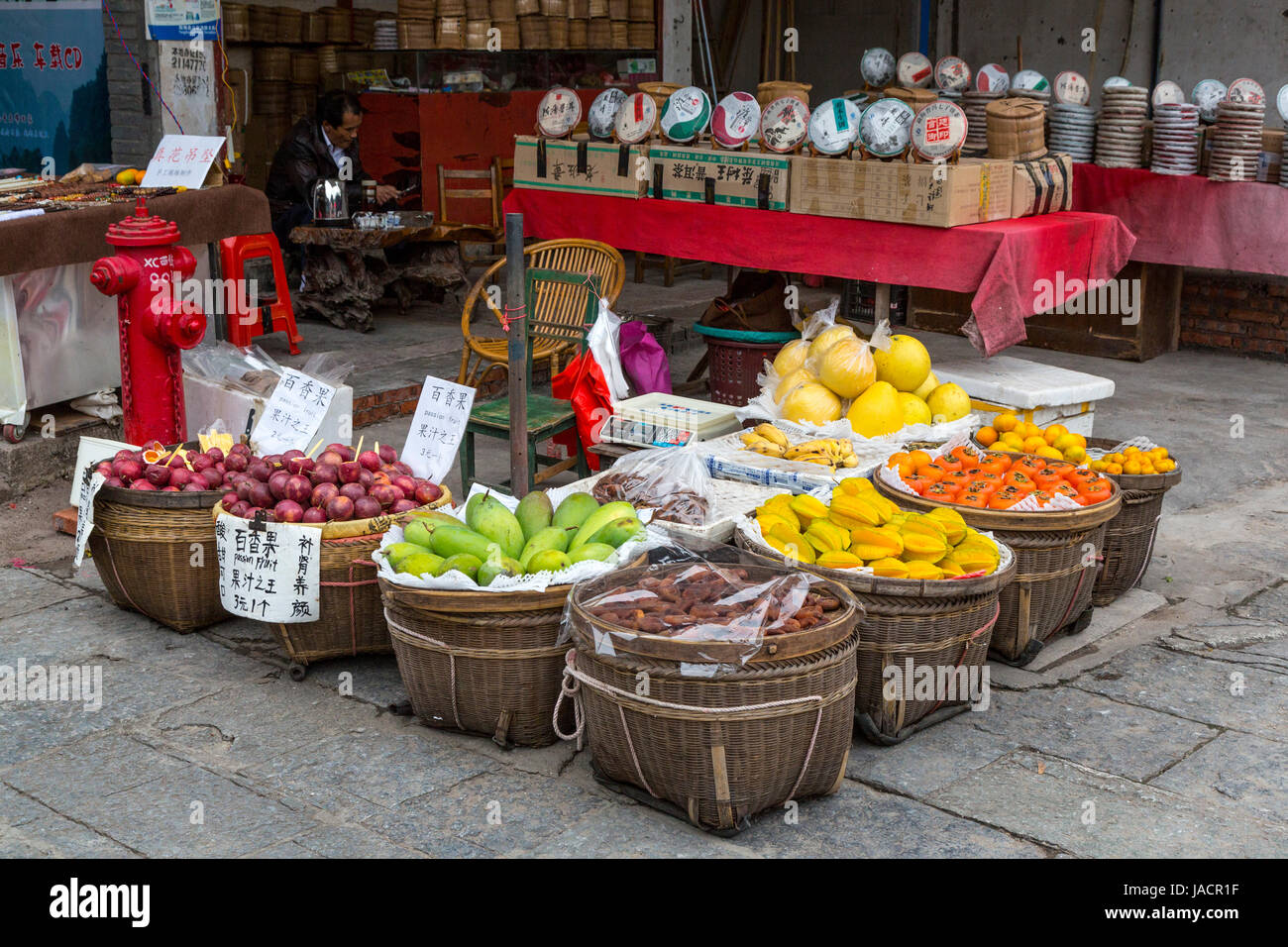 Yangshuo, China.  Körbe mit Obst zum Verkauf an Bürgersteig Ecke. Stockfoto