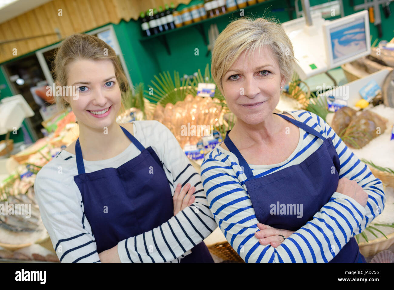 lächelnde Verkäuferinnen arbeiten am Schalter im Fisch-Shop Stockfoto