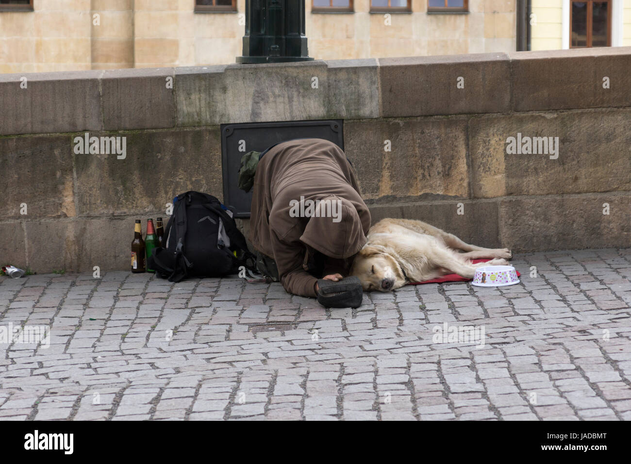 Ein Bettler bettelt und sein Hund lag auf der Straße, auf der Zufahrt zur Karlsbrücke, Prag, Tschechien Stockfoto