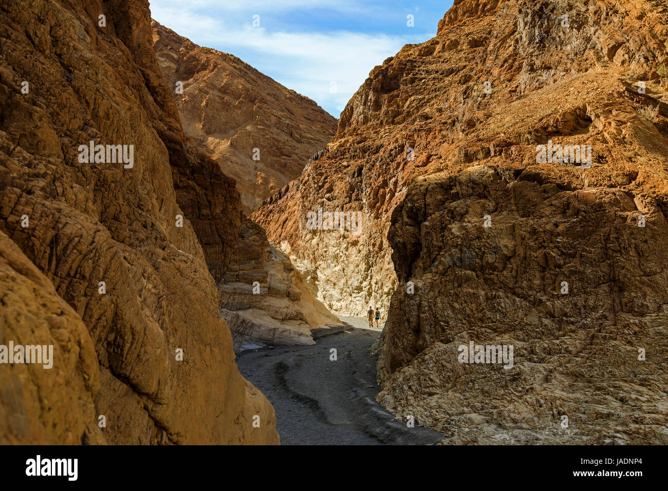 Gehen Sie in diesem Bild zwei Wanderer durch einen Teil der Kupfer-farbigen Narrows Mosaic Canyon in Death Valley Nationalpark, Kalifornien, USA. Stockfoto