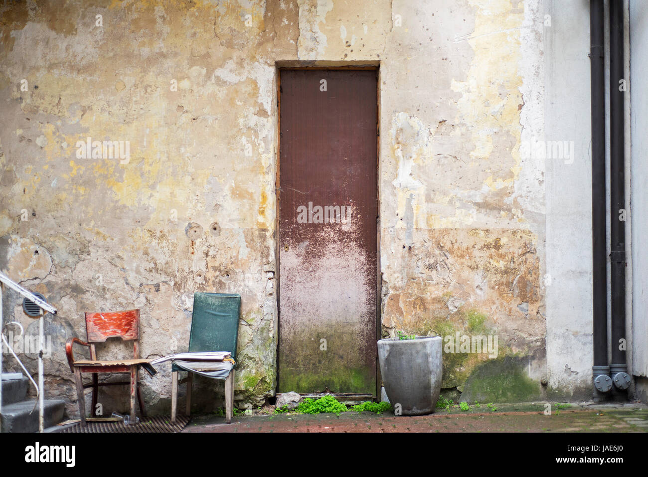 Topf für Blumen, zwei Stühle in der Nähe von verlassenen Grunge rissige Wand Stockfoto Topf für Blumen, zwei Stühle in der Nähe von verlassenen Grunge rissige Wand Stockfoto