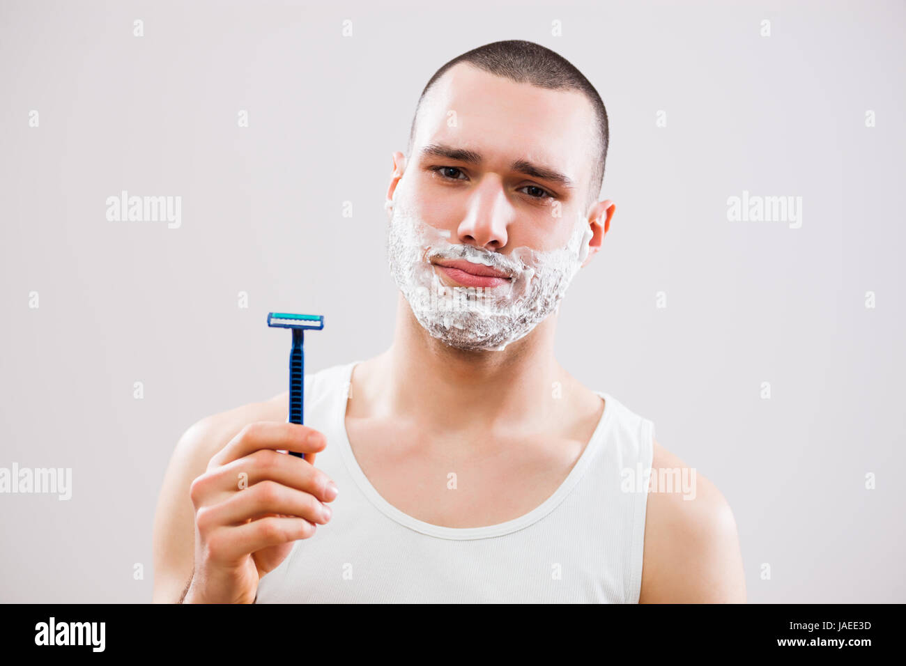 Junger Mann ist langweilig, denn er hat seinen Bart rasieren. Stockfoto