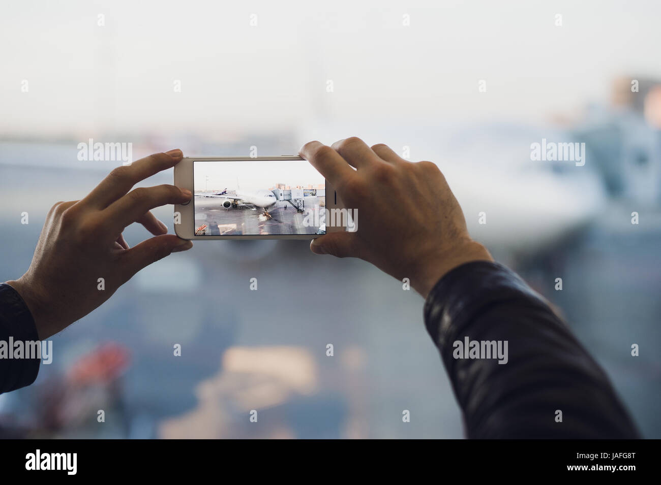 Hand des Menschen fotografieren Sie Flugzeug mit Handy. Tourismus-Konzept Foto Stockfoto