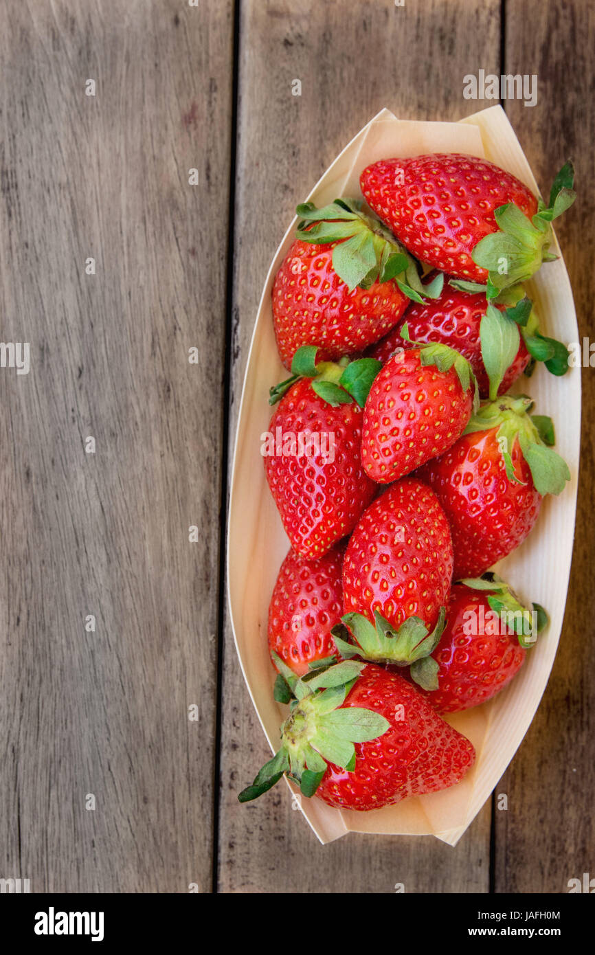 Reife Bio-Erdbeeren in Birkenrinde Schüssel auf dunklem Holz, Draufsicht, Sommer, gesundes Essen, sauber Essen, Konzept, Draufsicht, Exemplar Stockfoto