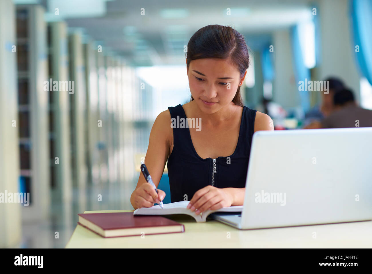 eine hübsche junge asiatische oder chinesischen College Student Studium in der Bibliothek Stockfoto