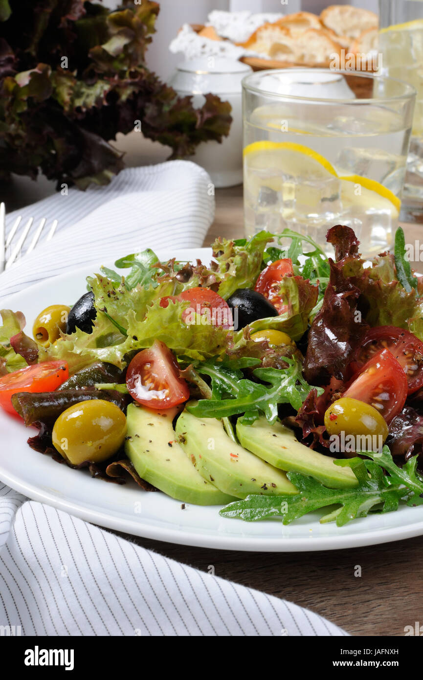 Sommer-Salat - mit Avocado, Oliven, Tomaten in Salat gekleidet, Senf-Knoblauch-sauce Stockfoto