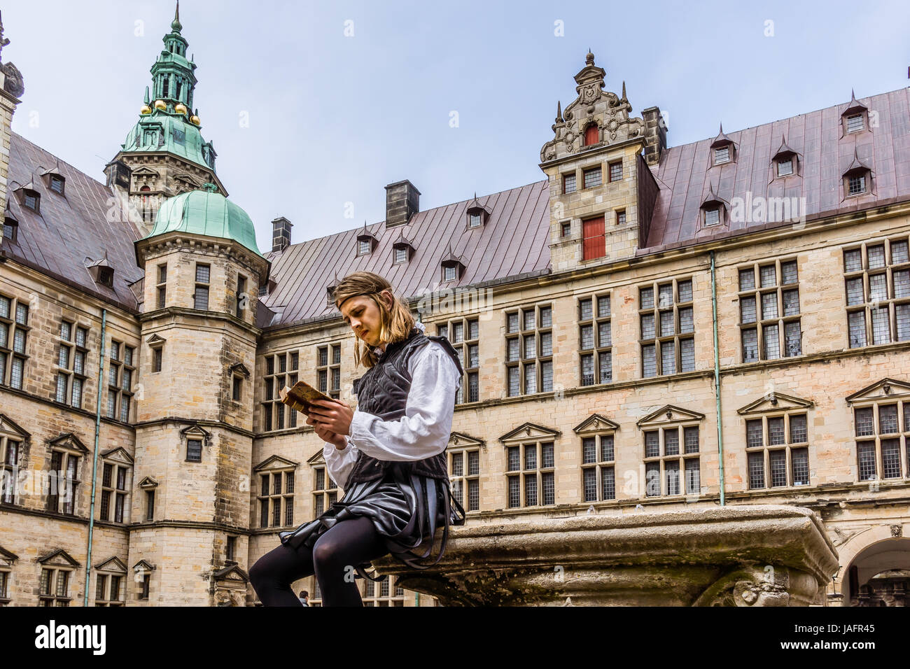 Schauspieler, die Durchführung von Prinz Hamlet und liest ein Buch auf Schloss Kronborg, Helsingør, Dänemark, 26. Mai 2017 Stockfoto