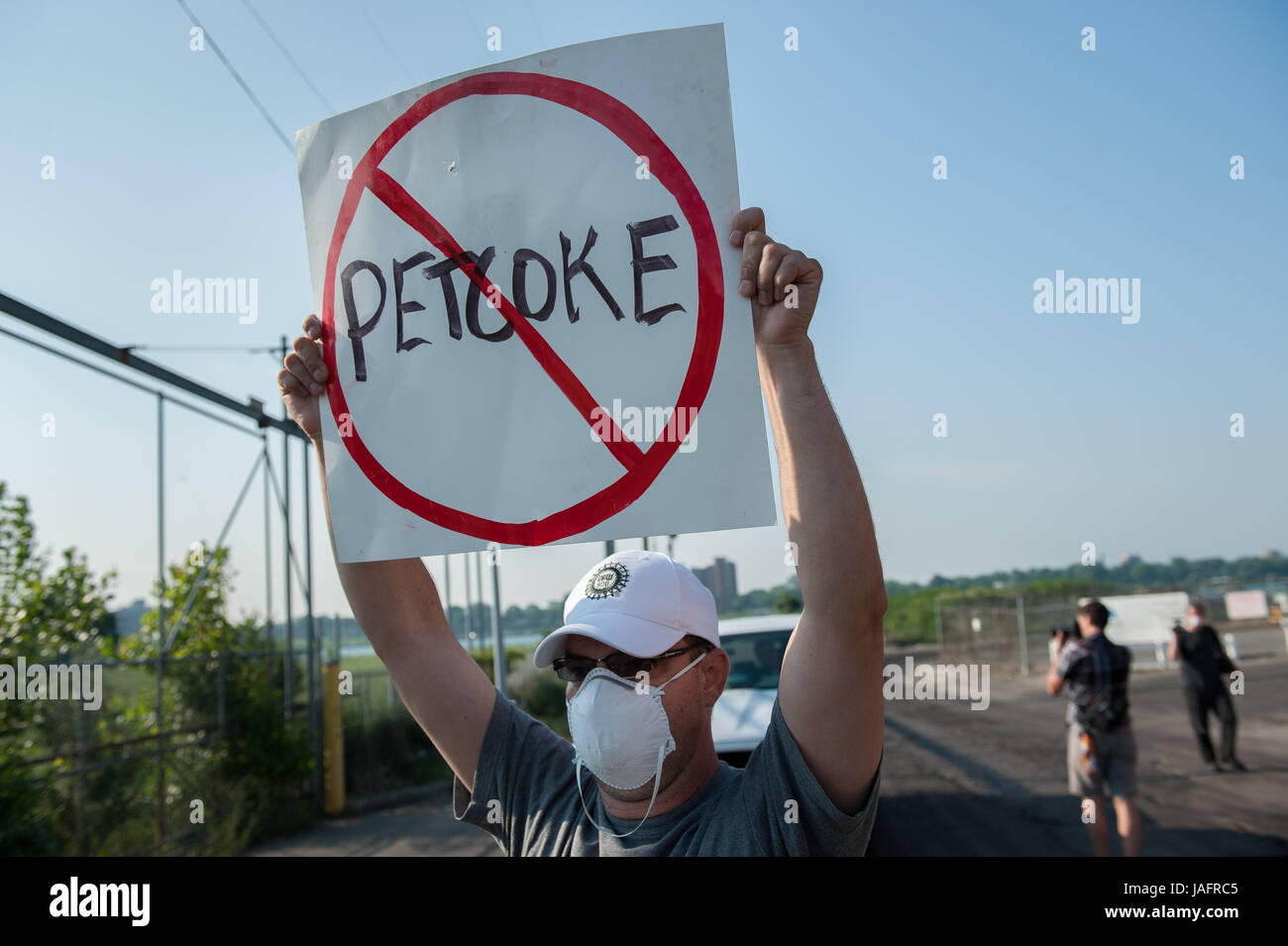 Unterstützer und Mitglieder von Detroit Koalition gegen Tar Sands (DCATS) blockieren einen Lkw schleppen Petrolkoks, den umstrittenen Lagereinrichtung und Docks entlang den Detroit River im Juni 2012. Mit Detroit Polizei und Homeland Security Officers bereitzustehen, die Gruppe den LKW für fast drei Stunden vor der Zustimmung zu erlauben es zu drehen ohne dumping seine Last Haustier Koks statt. Petrolkoks lagerte aufgedeckt entlang den Detroit River von 2012 bis Ende 2013, wenn die Stadt nach einem öffentlichen Aufschrei über Umweltbelange entfernt giftige Pfähle bestellt. Stockfoto