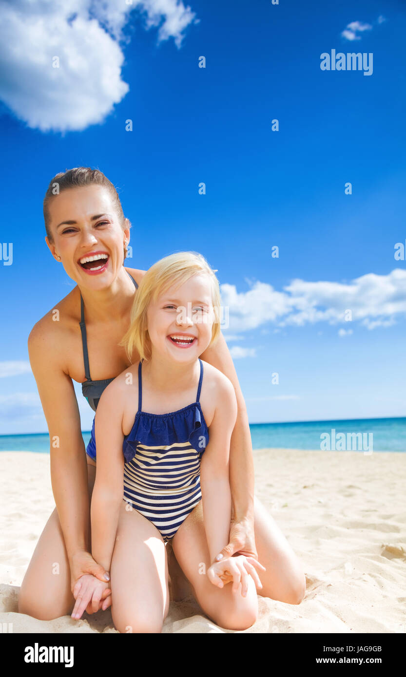 Sonnenverwöhnten Schönheit. glückliche junge Mutter und Tochter im Badeanzug  auf die Seeküste Spaß Zeit Stockfotografie - Alamy