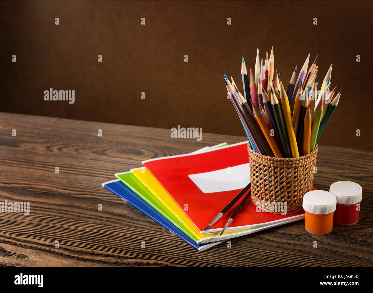 Bleistifte, Farben und Pinsel auf Holztisch. Stockfoto