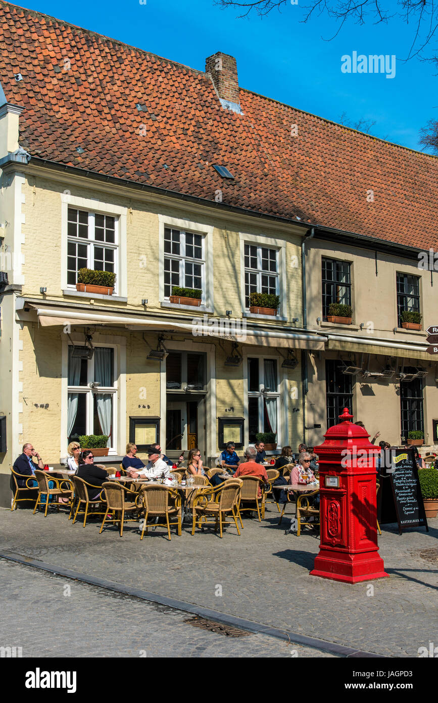Touristen, die an den Tischen in einem Straßencafé, Brügge, West-Flandern, Belgien Stockfoto