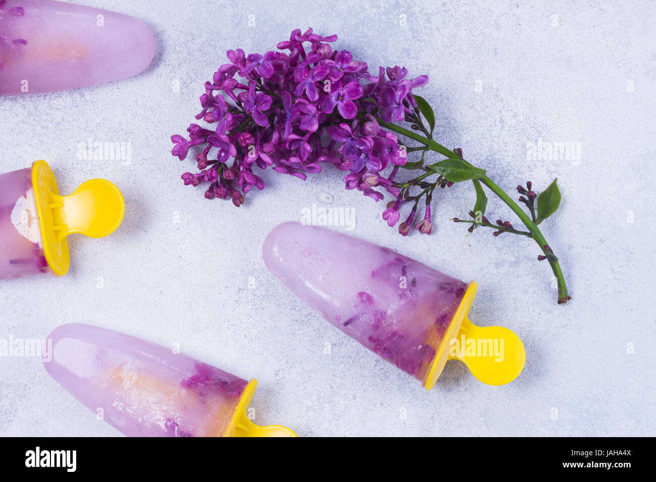 Eis am Stiel mit lila Blumen Stockfoto