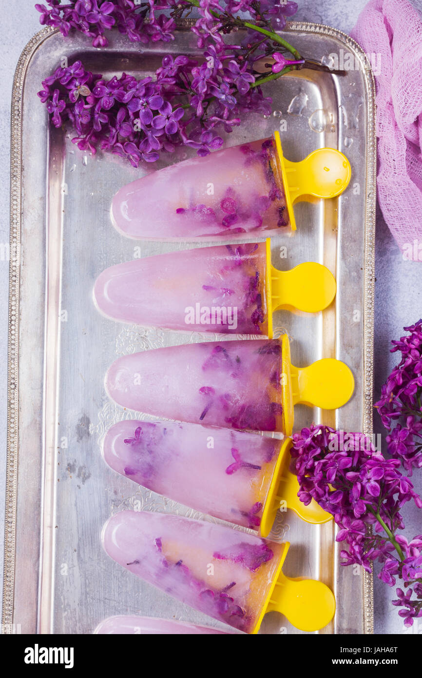 Eis am Stiel mit lila Blumen Stockfoto