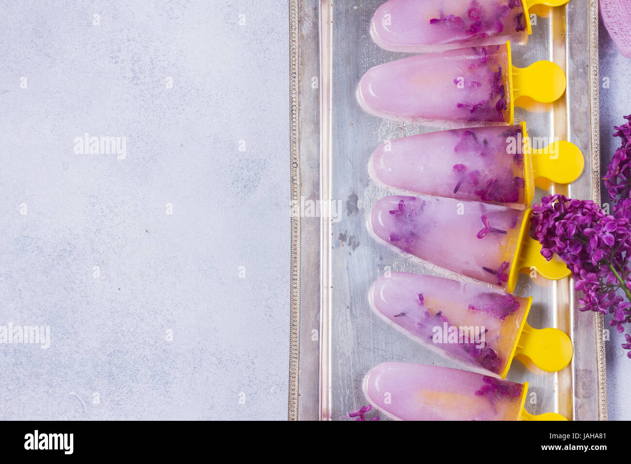 Eis am Stiel mit lila Blumen Stockfoto
