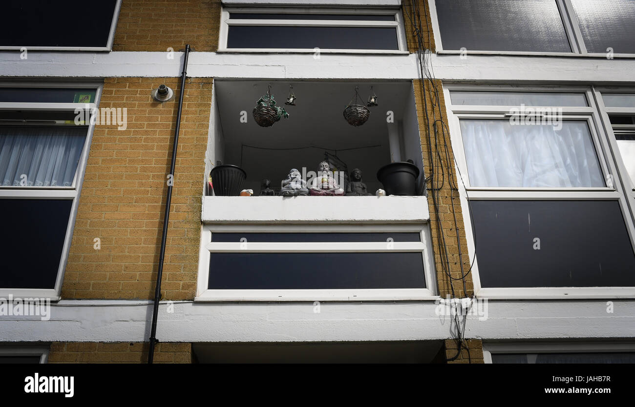 Buddha-Statuen sitzen auf einem sonnigen Balkon in einer flachen Innenstadt Stockfoto