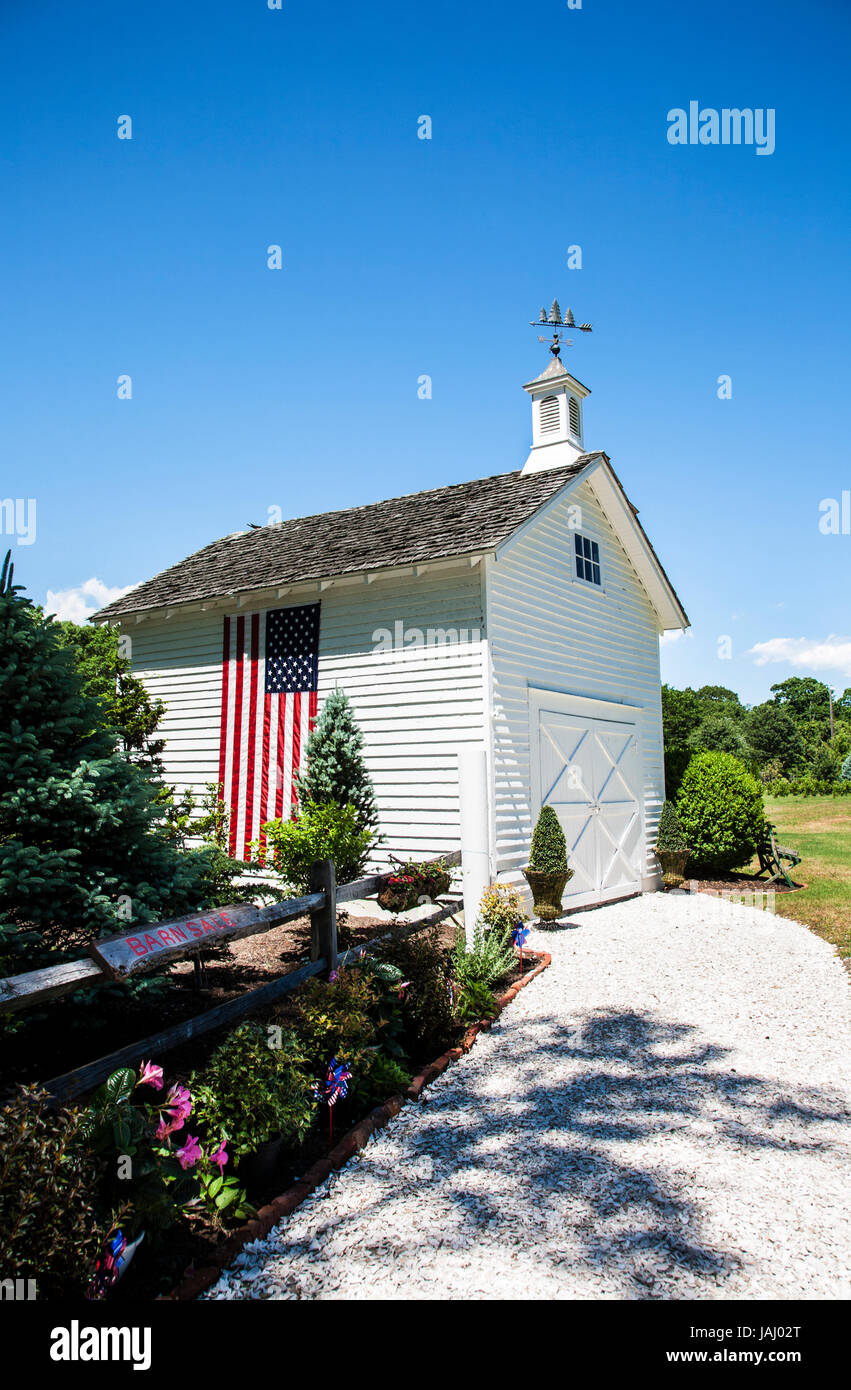 Amerikanische Flagge auf einer alten restaurierten weißen Scheune mit einer zusätzlichen Kuppel, Cape May County, New Jersey, US-Flagge Rural America, 2017, pt Holzgartenschuppen Stockfoto