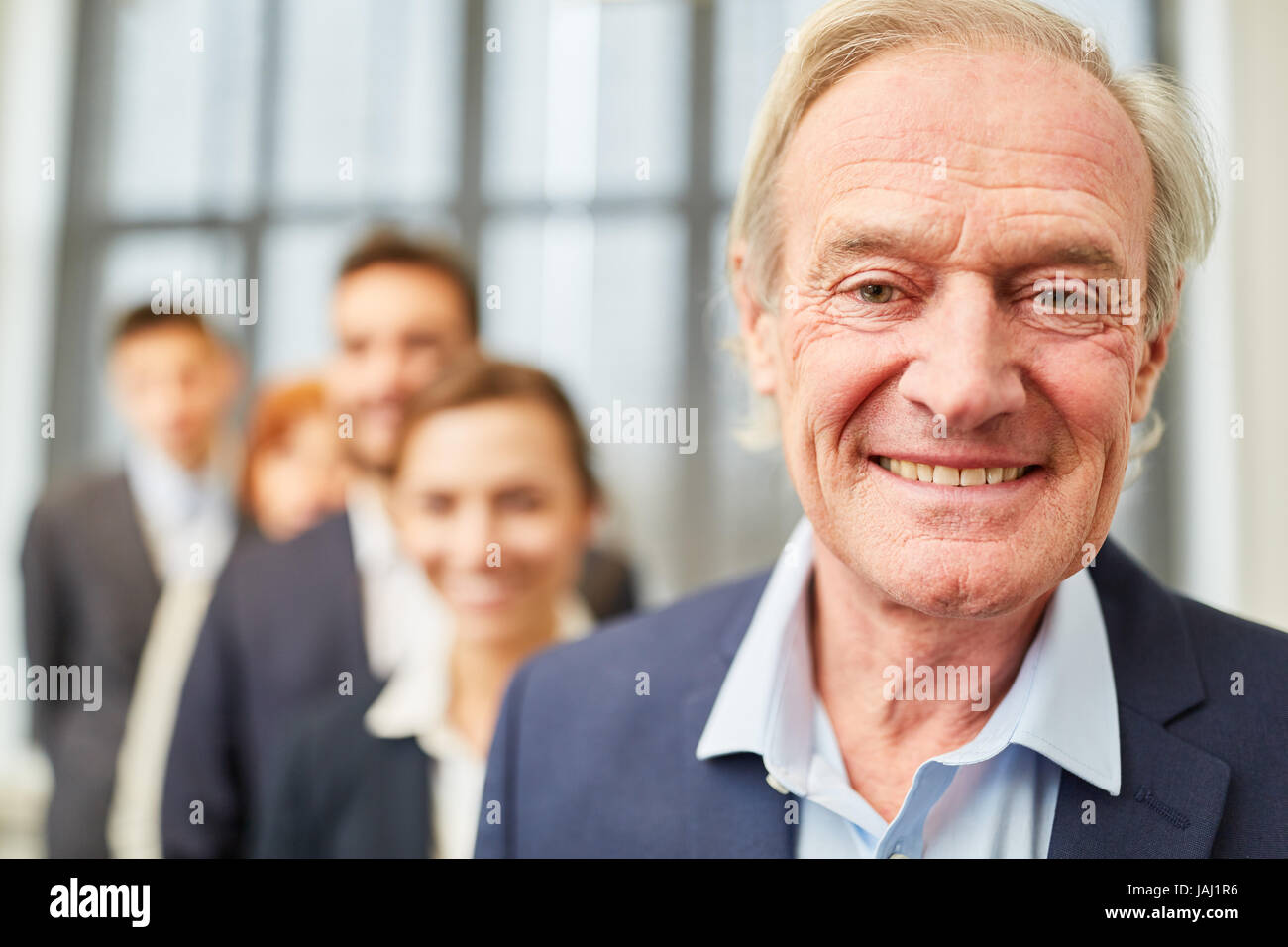 Ältere Menschen als Chef oder Geschäftsführer lächelnd mit seinem team Stockfoto