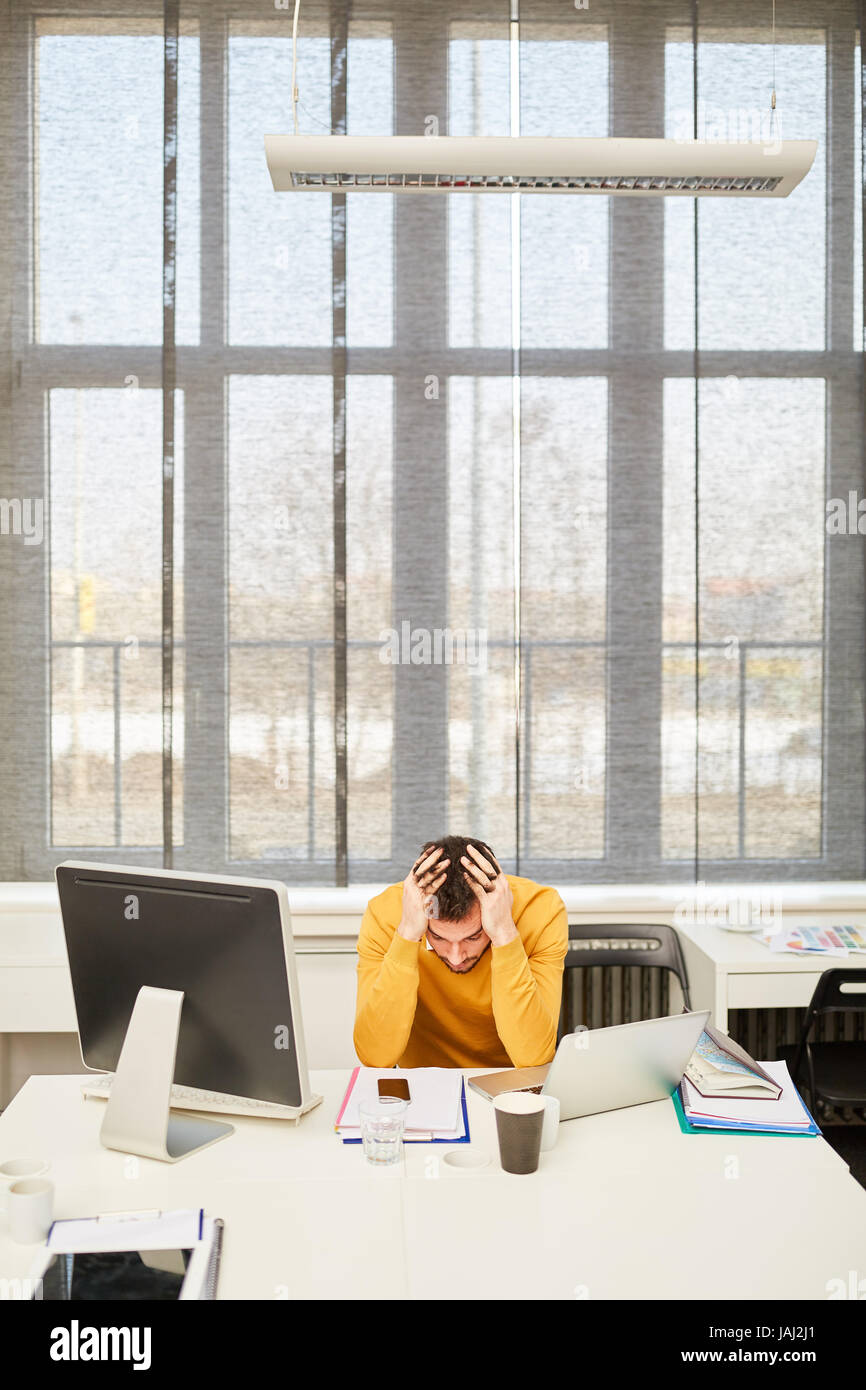 Mann als CEO mit Geschäftsproblem oder Krise hält seine Hände auf den Kopf Stockfoto