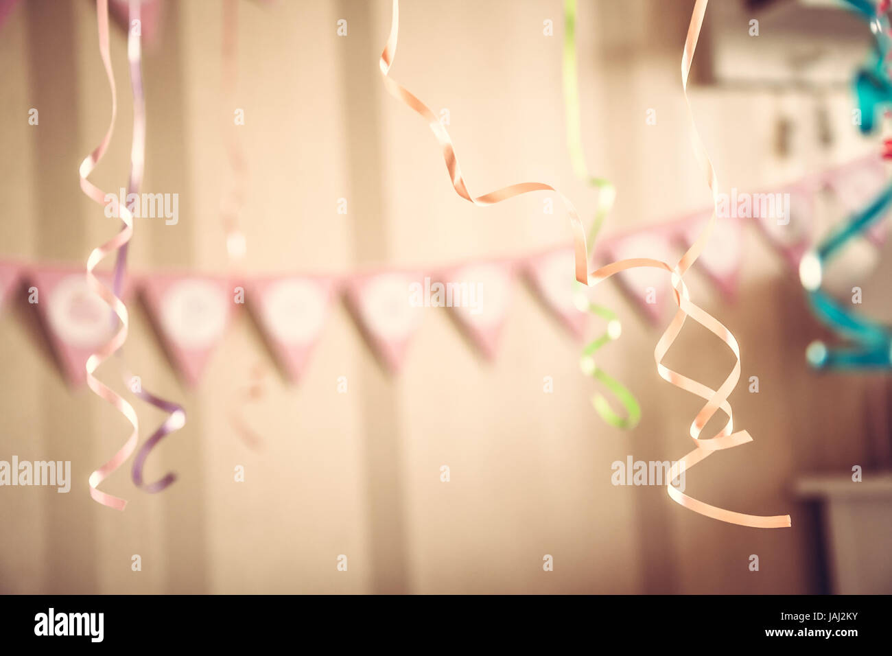 Jahrgang alles Gute zum Geburtstag-Partei unscharf Hintergrund mit hängenden Bändern und Garland in eingerichteten Zimmer in Pastellfarben Stockfoto