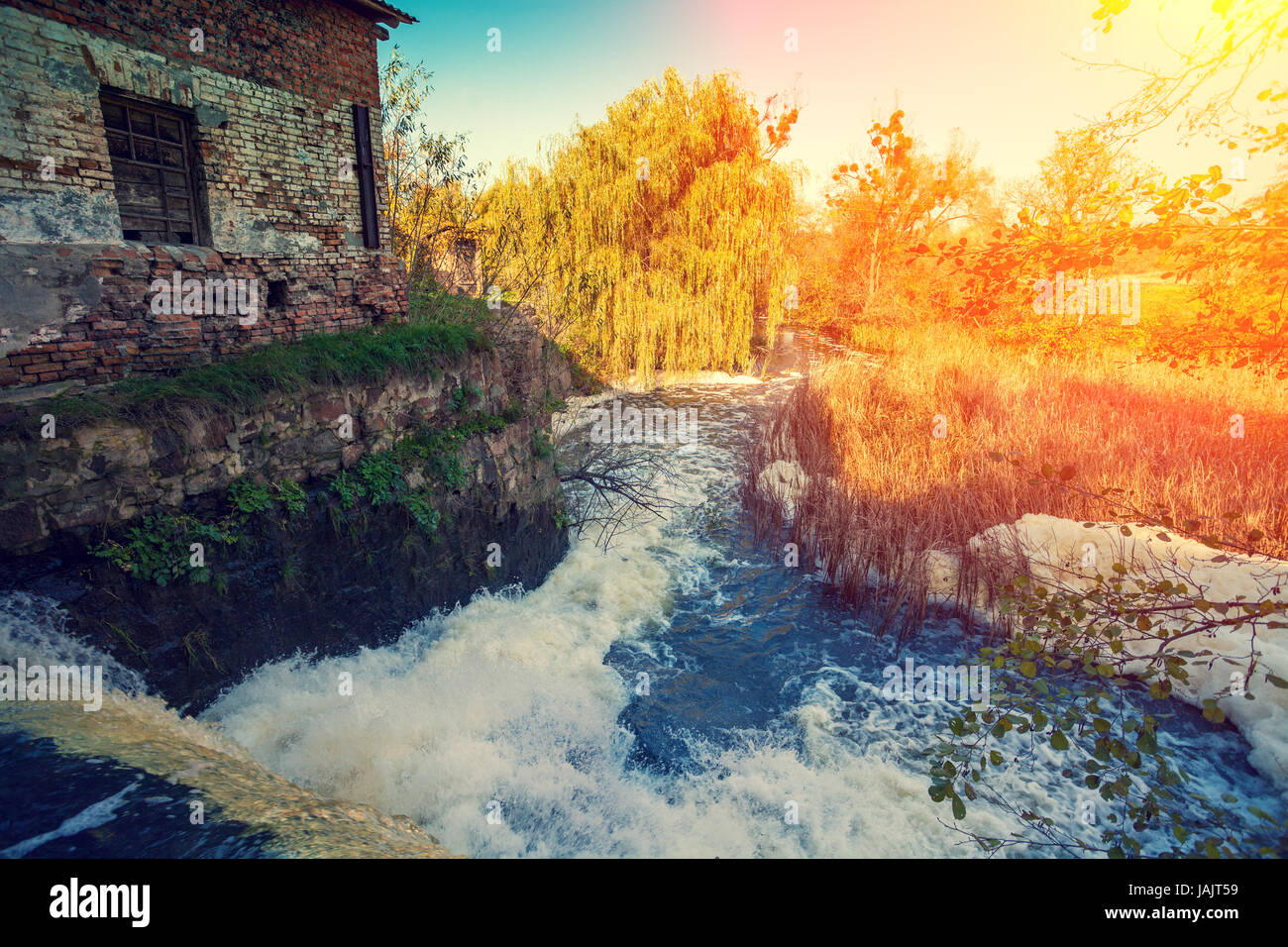 Wasserfall und Wassermühle bei Sonnenuntergang Stockfoto