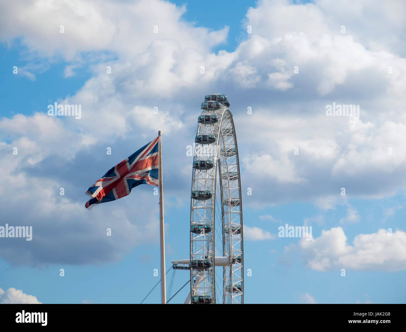 Das London Eye Riesenrad mit dem Union Jack vorne auf einem Fahnenmast Stockfoto