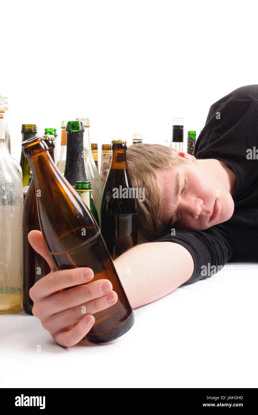 Junger Mann Mit 100-jähriges blonden Haaren Liegt Auf Dem Boden Und ist von Vielen enthalten Bier-Und Schnapfsflaschen diesen, Isoliert Vor Weißem Hintergrund. Stockfoto