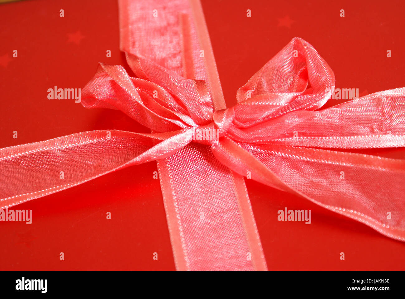 Eine Makroaufnahme von einem roten Band gebunden in einem Bogen um ein Geschenk-Box. Stockfoto