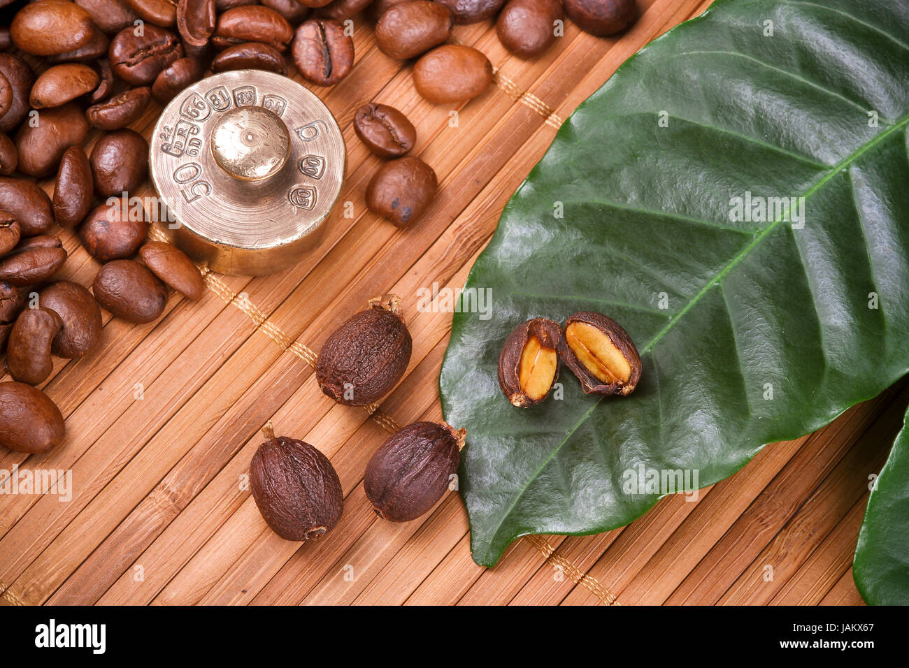 Geröstete Kaffeebohnen und Früchte und Blätter Stockfoto