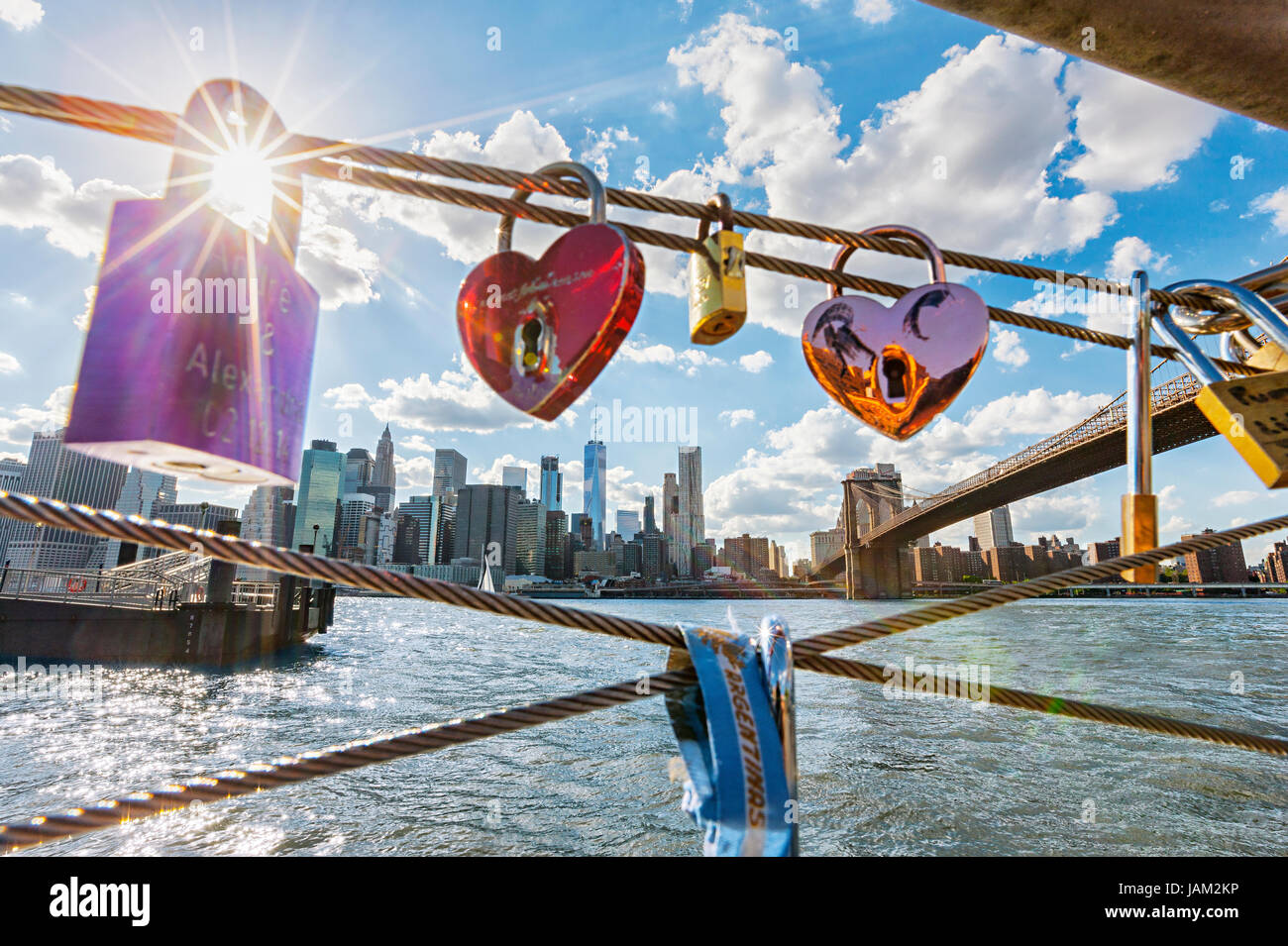 Sonne strahlt Trog Vorhängeschloss auf dem Zaun. Blick auf die Brooklyn Bridge und Manhattan auf dem Hintergrund, New York City Stockfoto