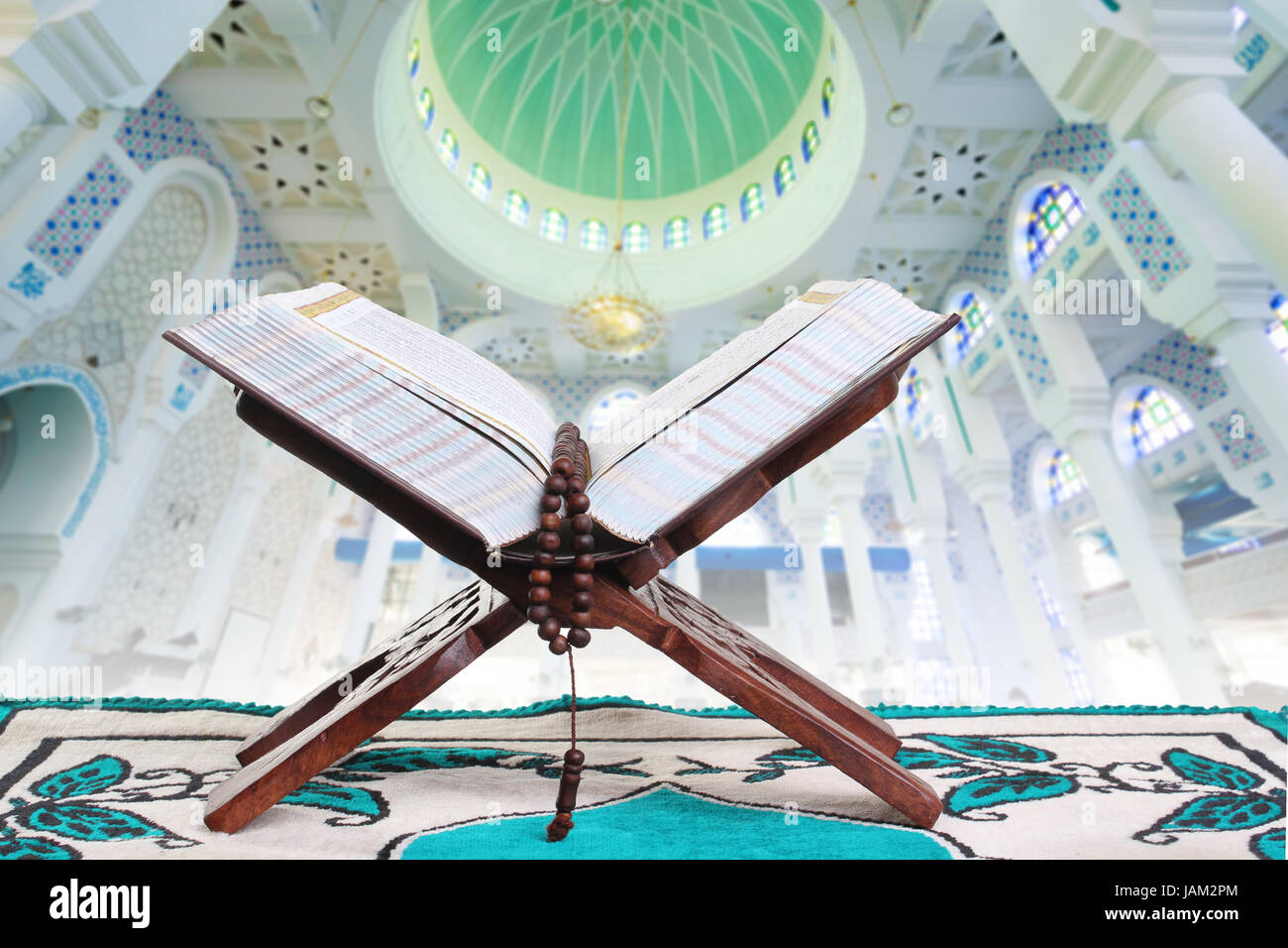 Islamische Buch des Koran offen für rezitieren mit Perlen mit Moschee innen Hintergrund Stockfoto