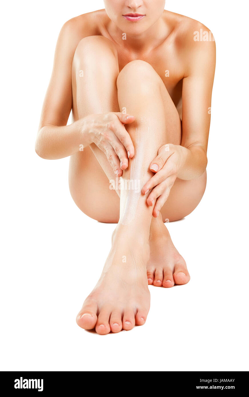 Feuchtigkeitscreme Creme auftragen. Pflege für weibliche Beine isoliert auf weißem Hintergrund Stockfoto