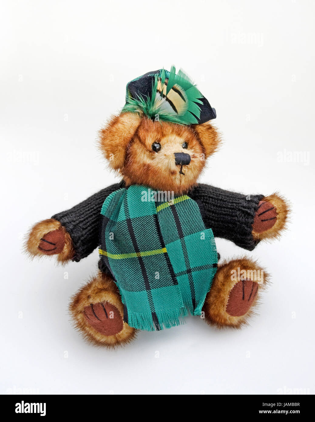 Süße kuschelige schottischen Teddybär wollige Pullover, Tartan Schal und Mütze mit Tartan Feder Plume tragen. Stockfoto