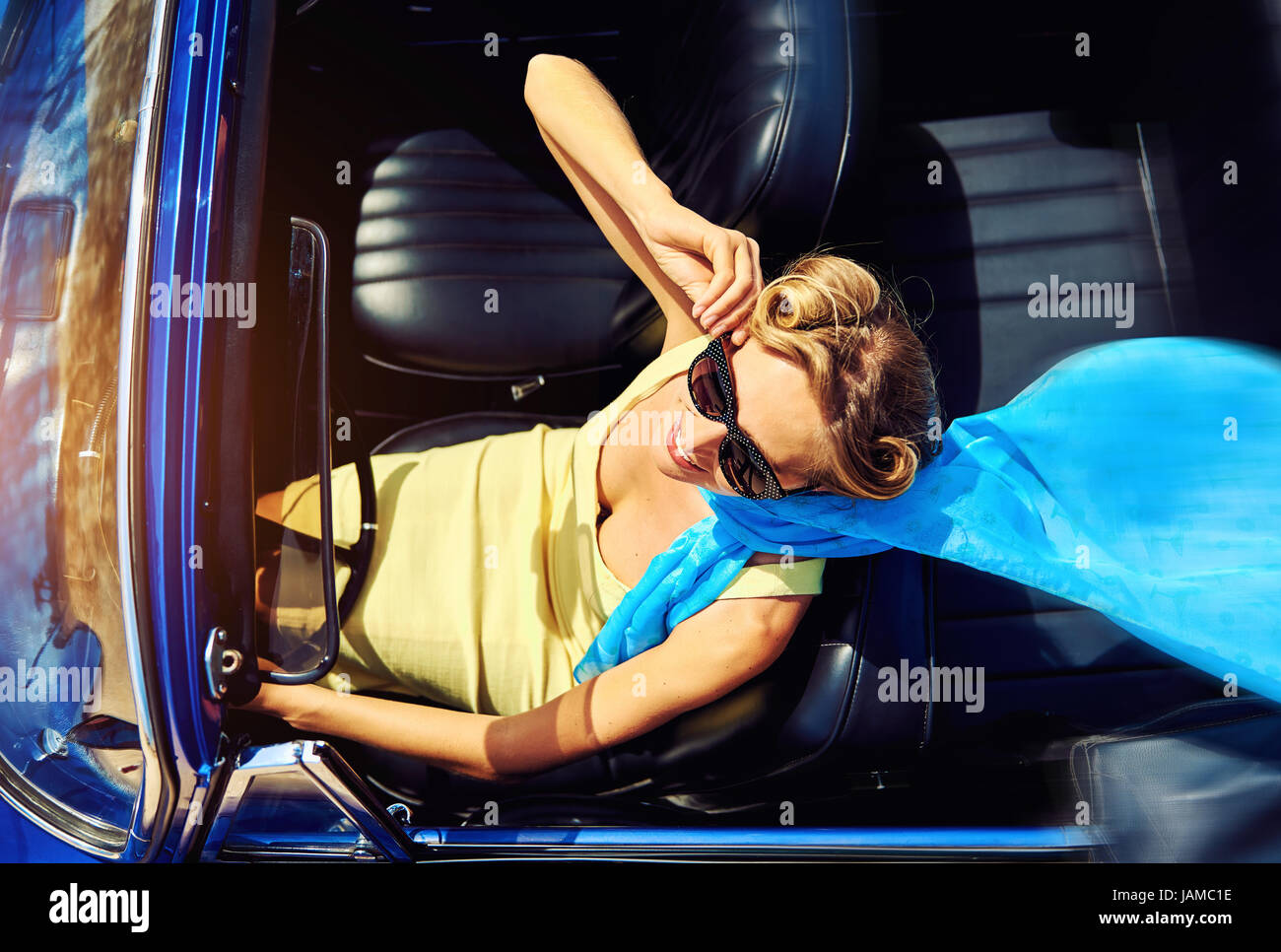 Attraktive Frau im Retro-Auto Stockfoto