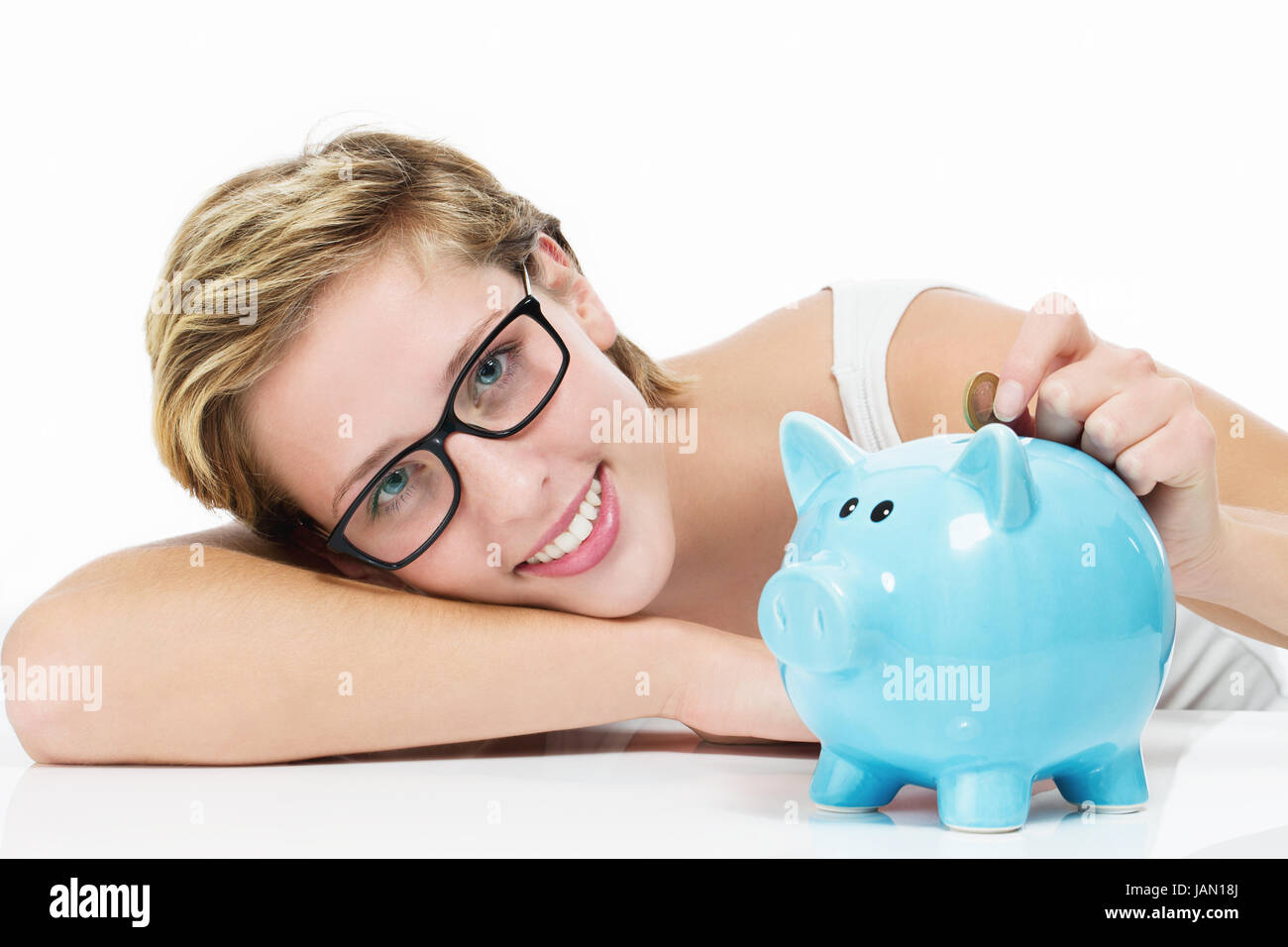 Glückliche Frau Wirft Münze in Ihr Sparschwein Auf Weißem hintergrund Stockfoto