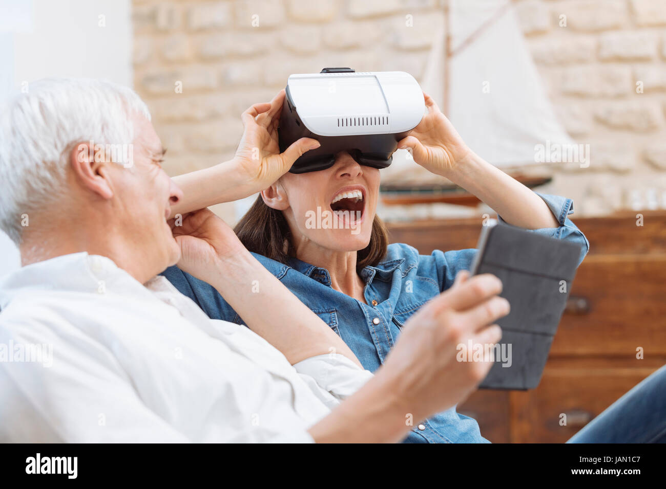 Älteres Paar mit digital-Tablette und virtual-Reality-Kopfhörer in Wohnzimmer Stockfoto