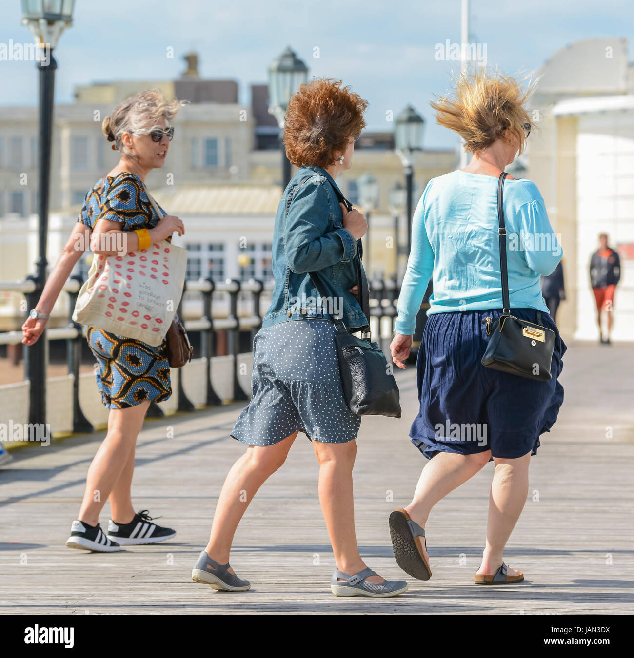 Windiger Tag. Frauen zu Fuß auf einem Steg am Meer in den Wind an einem windigen Tag. Stockfoto