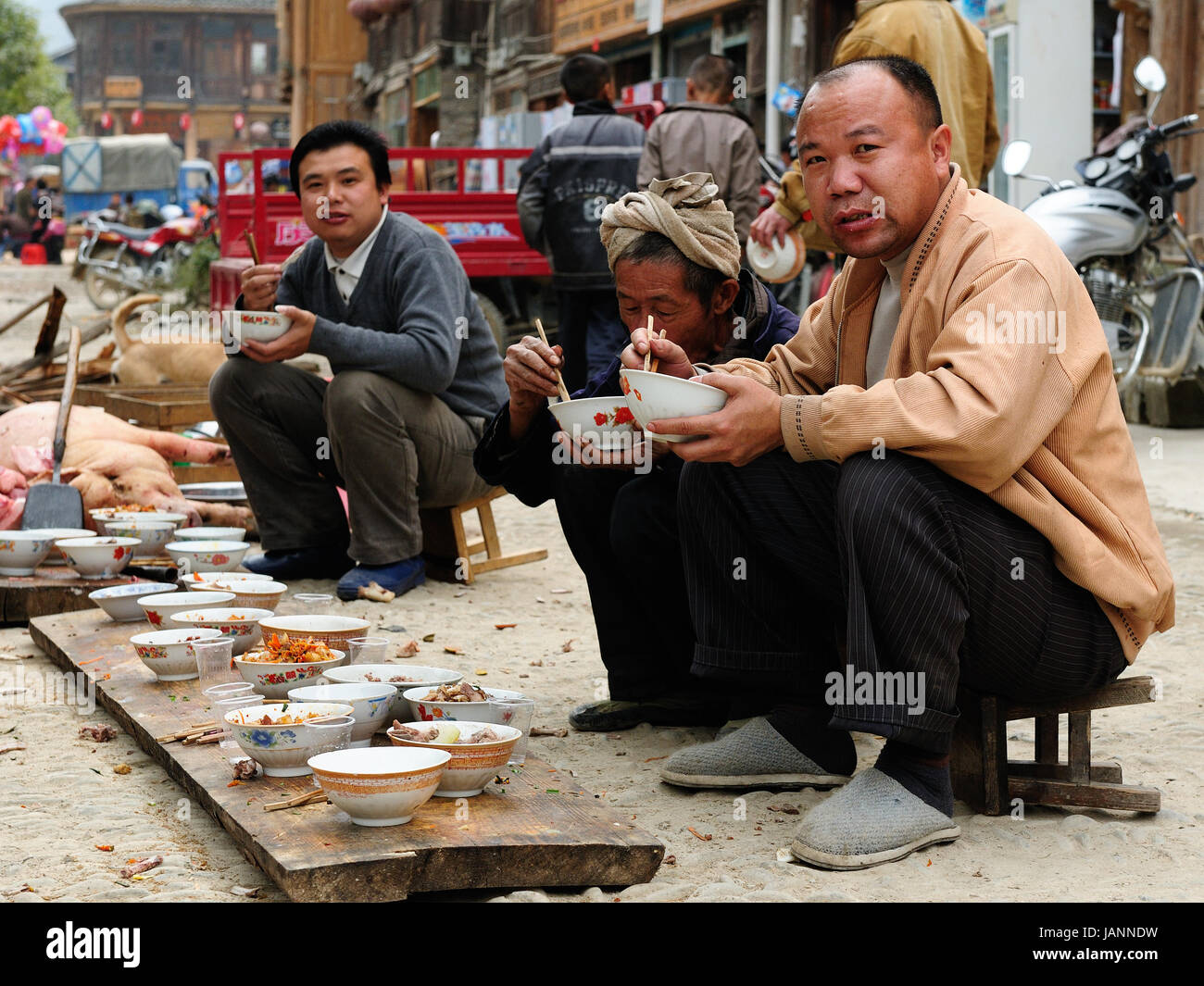 ZHAOXING, CHINA - 11. November 2010: Bewohner der Zhaoxing ist eine hübsche Dong Minderheit-Stadt auf der High Street auf der gemeinsamen Mahlzeit essen Stockfoto